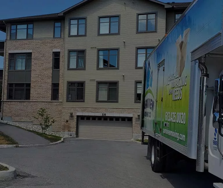 A moving truck parked in front of an apartment building ready to give a free quote.