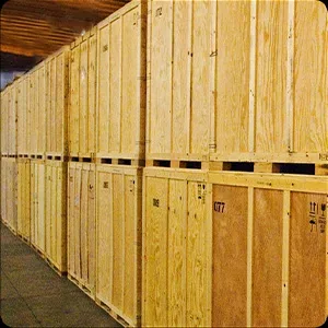 Rows of large wooden crates in a storage area, with photos pinned on several crates.