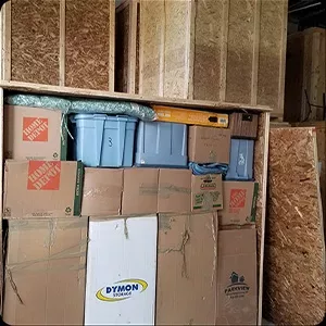 Stacked moving boxes and plastic bins in a storage area, reminiscent of a carefully curated photo gallery.