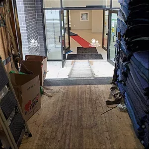 An entrance hallway with a pile of cardboard boxes to the left and a stack of blue mats to the right, perfect for a photo opportunity.