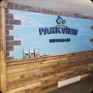 Reception area of parkview movies with a wooden counter and photos on the branded wall graphic.