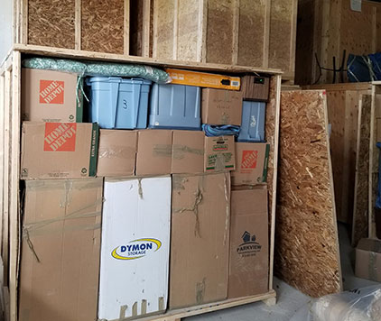 Organized storage unit filled with labeled cardboard moving boxes, plastic bins, and neatly stacked household items at Parkview Moving’s Ottawa facility.