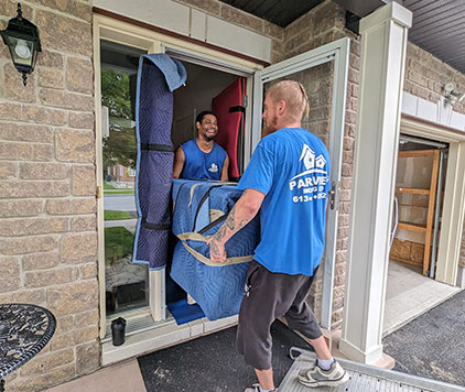 Two movers carefully handling furniture during a long distance move with all items well-protected for safety.