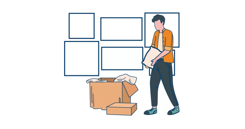 A man is adding a thin cushion to the top of his packed boxes for extra padding.